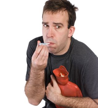 Closeup of a sick man taking his temperature and holding a hot water bottle to his stomach, isolated against a white background