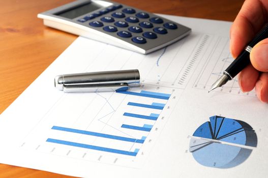 business data in office with hand witch calculator
