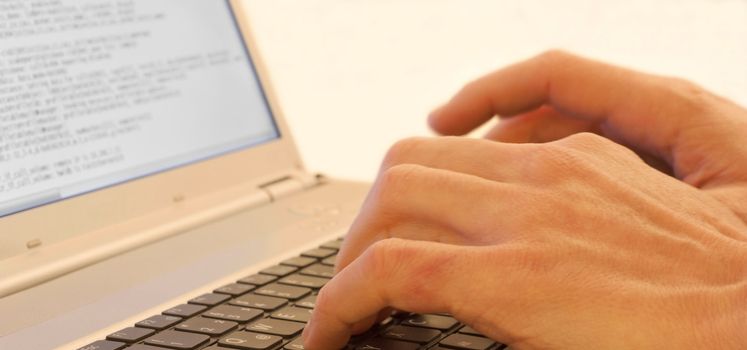 Hands typing on a laptops keyboard