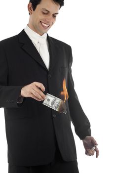 A good looking young business man burning a 100 dollar bill and smiling.