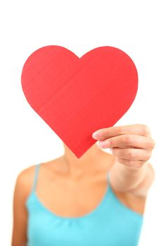 Woman holding Valentines Day heart sign with copyspace. Model isolated on white background. Shallow depth of field with focus on the heart sign.