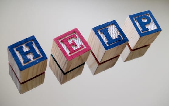 The word help spelled out in children's toy blocks
