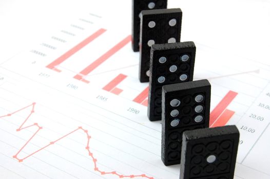 domino over business chart showing the risk of financial or banking crisis