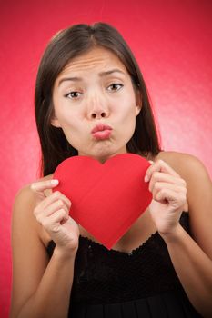 Valentines day alone? Woman looking for love holding a Valentines Day heart sign. Beautiful mixed race asian (chinese) / caucasian model.