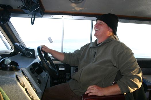 Young fisherman piloting a trawler onto Kachemak Bay, a fertile fishing ground