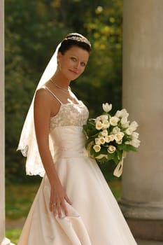 Beautiful bride with bouquet in park