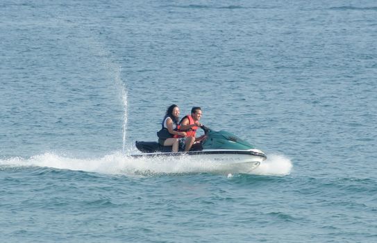 couple on jet ski riding and smiling