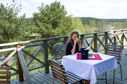 Young girl with apple on veranda