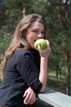 Young girl with apple on forest background