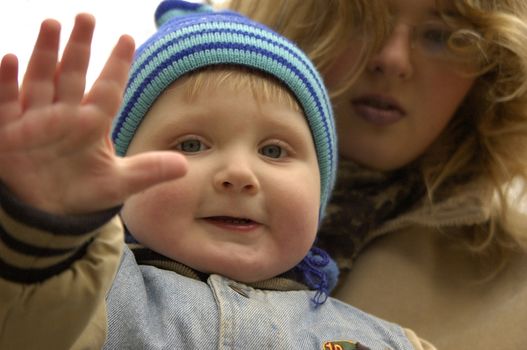 Воу waving hello (with a mother)