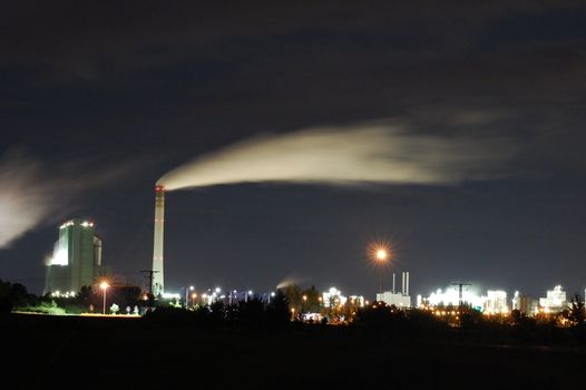 a smoking industrial power plant at night