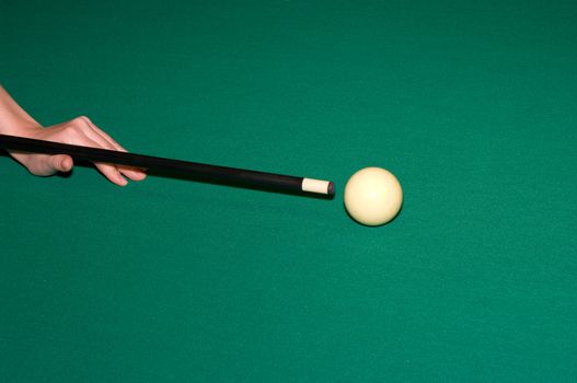 Player's hand, cue and cue ball on the table.