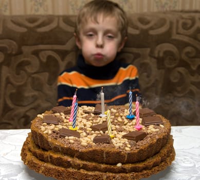 The boy has blown into candles on a celebratory pie.