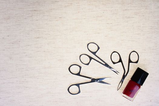 The special tool for care of nails with a small bottle red a varnish against from a fabric.