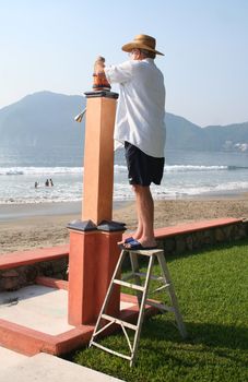Man changing light bulb on lamp in beachfront yard
