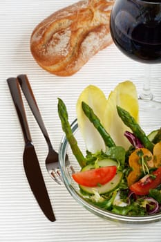 glass bowl of fresh salad with green asparagus