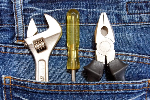 tools like caliper screwdriver and spanner in jeans pocket
