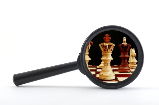 business competition concept with chess pieces and magnifying glass