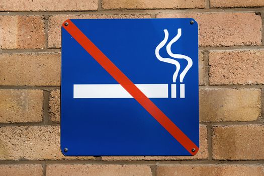 Blue no smoking sign on a red brick wall