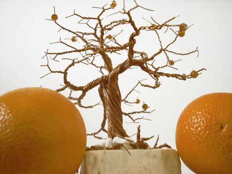 Some oranges and a man-made copper tree
