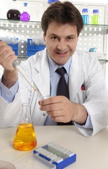 Scientist dispensing liquid from a pipette into a centrifuge tube.  He is looking up and smiling.