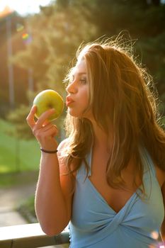 Girl with apple on sunset