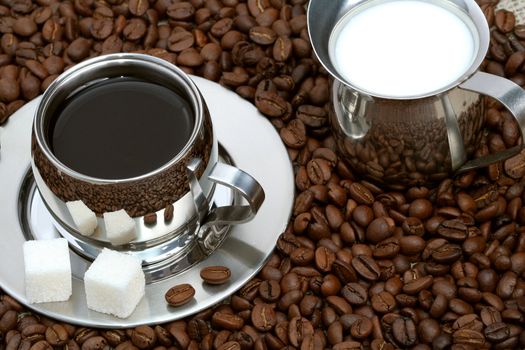 Cup of coffee with lump sugar, milk and coffeebeans, coffee series