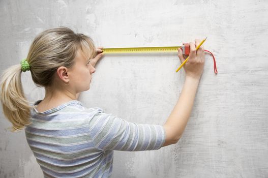 worker woman measuring on wall straightedgetape measure