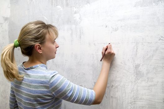 one young blonde with pencil in hands at wall