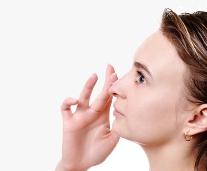 Young beautiful girl applying cream on her face