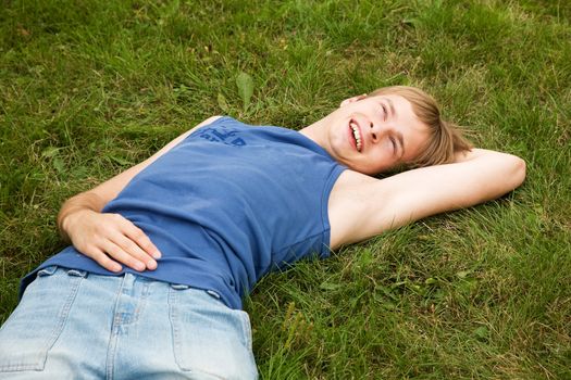 Smiling boy lying on the green grass