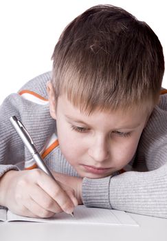 boy drawing a pencil picture lying on the floor isolated on white