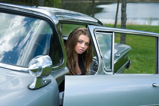 Young girl in short skirt in old-fashioned car