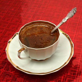 Cup of coffee with the spoon on a red background, (look similar images in my portfolio)