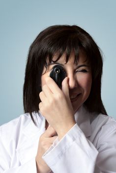 A female optician turning the wheel dial of an opthalmoscope. closeup.