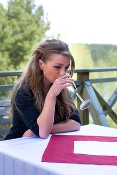 Young girl with glass of champagne on veranda