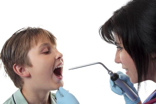 Closeup of a boy opening his mouth while a  doctor examining him using a bent arm illuminator.