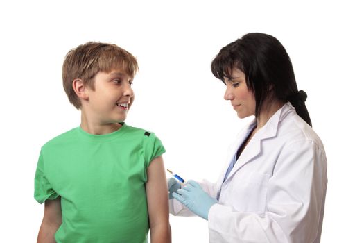 A happy boy receives a vaccination shot against a disease, virus or flu in his arm by a doctor or nurse.