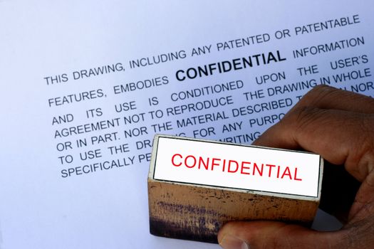 Confidential stamp over a confidentail warning words