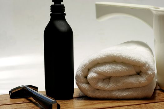 Men's Parfum with towel and shaver in a bathroom setting.