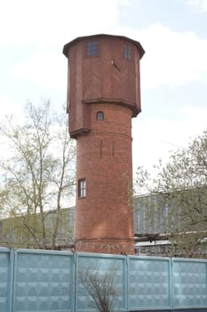 Water-tower after a fence with the barbed wire.