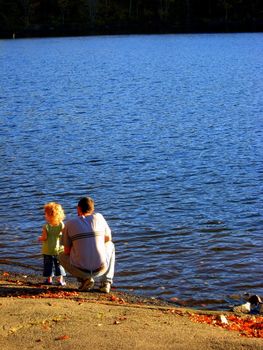father and young daughter, sharing family time at the lakeshore