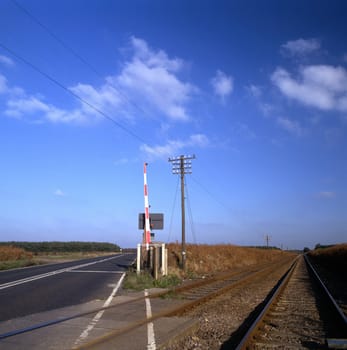 Road and rail crossing and disappearing into the distance