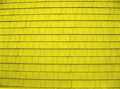 a wall of wood shingles, painted yellow