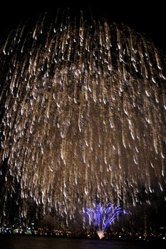 Spectacular Fireworks display with reflection in the water and city as the background