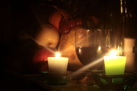 wine bottle with grapes glass and wine bottle by candlelight with tropical fruits
