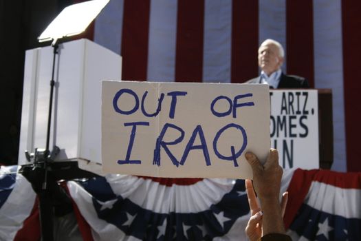Someone was expressing his opinion about the war in Iraq when McCain was giving his speech.  Focus on sign instead of McCain