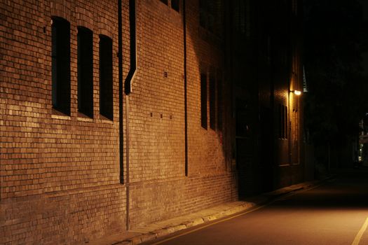 Mysterious Alley - Dark Abandoned Street With Lights Shining On A Brick Wall