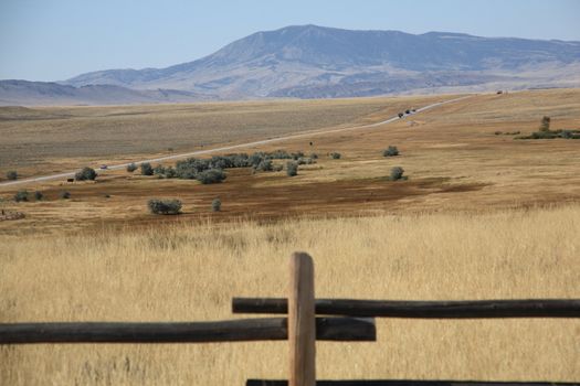 A distant highway cuts through back country Wyoming prairie.