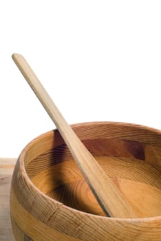 A spatula resting in an empty wooden bowl, with a solid white background